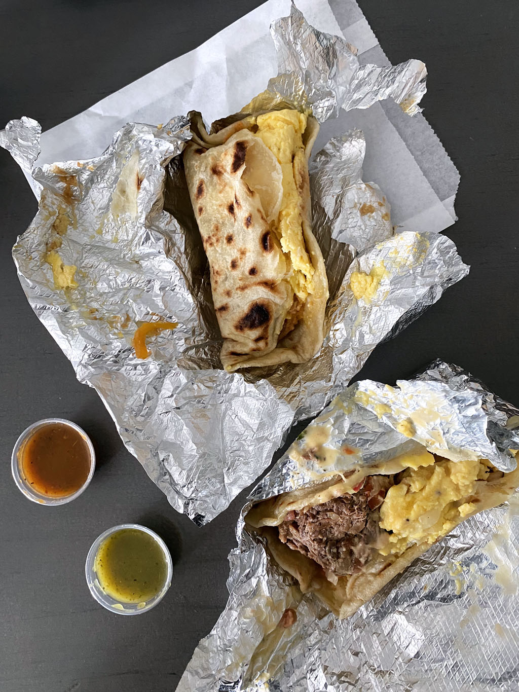 tin foil splayed out to show messy tacos inside