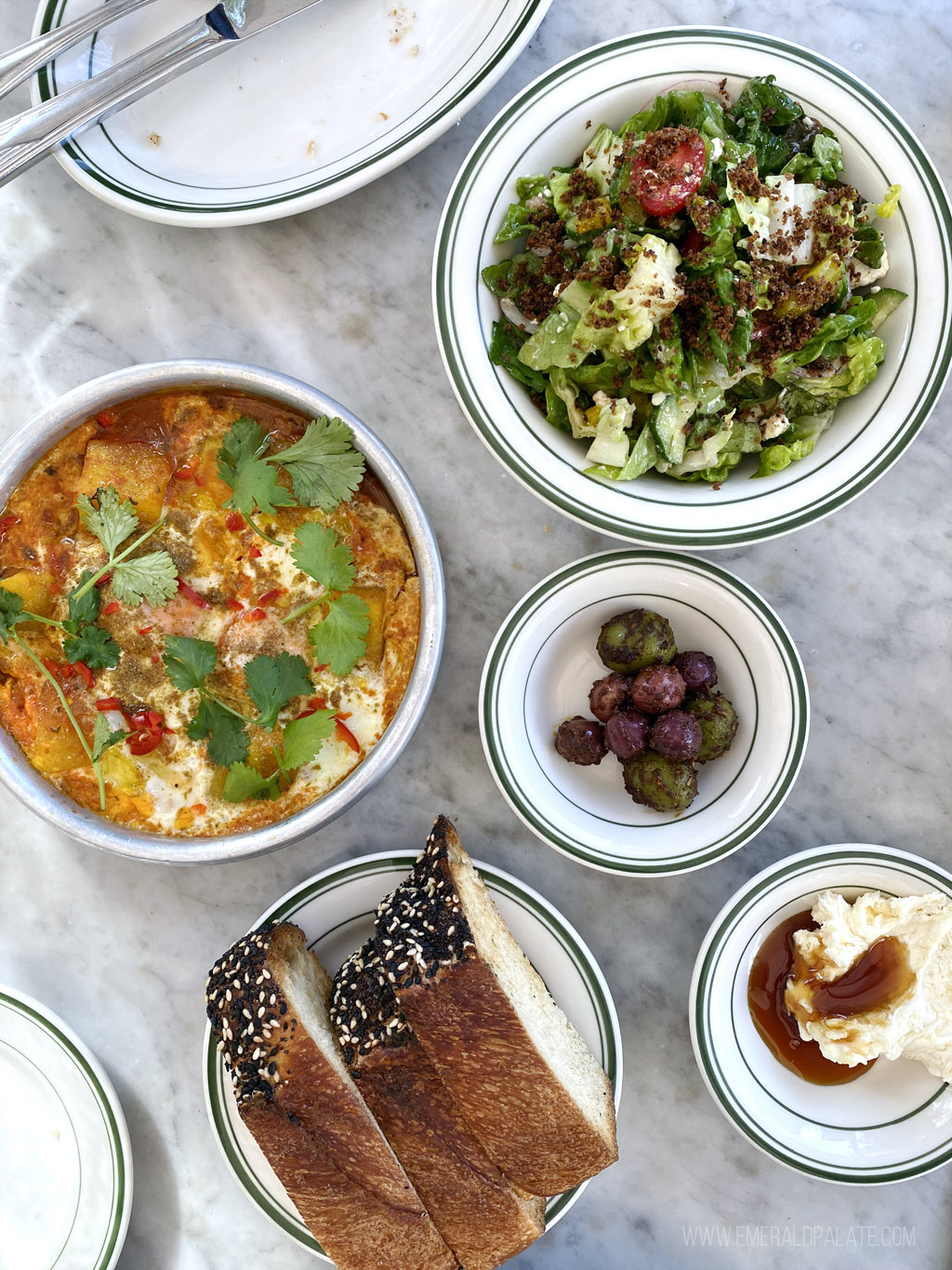 overhead photo of Mediterranean food scattered across a marble table