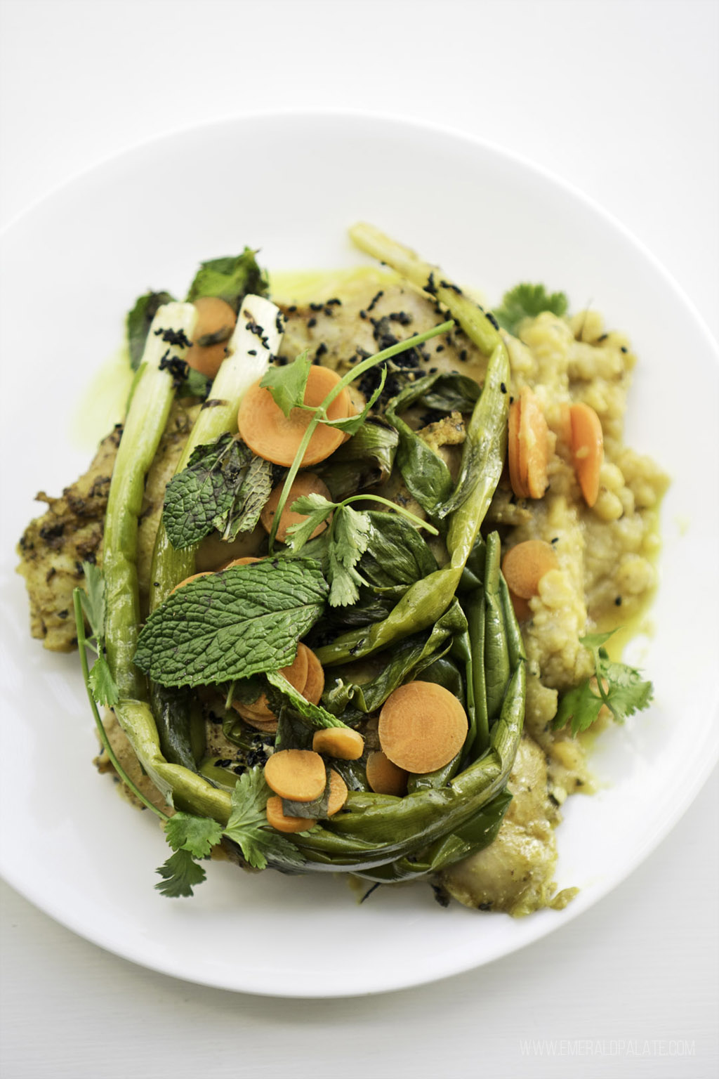 plate of risotto covered with seasonal vegetables