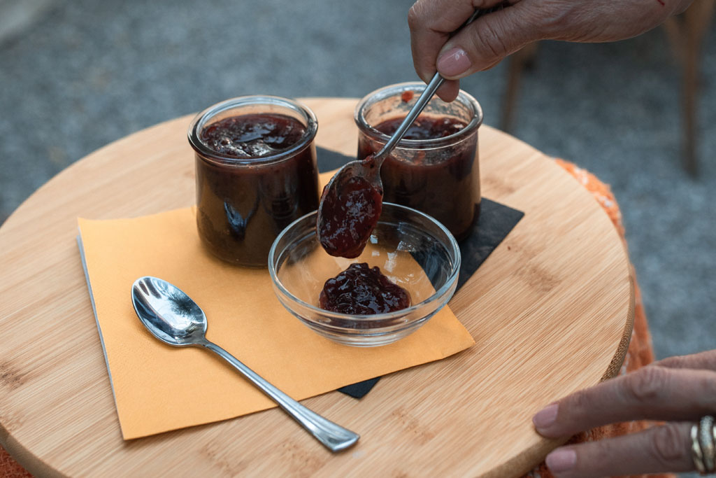 person spooning jam in a bowl