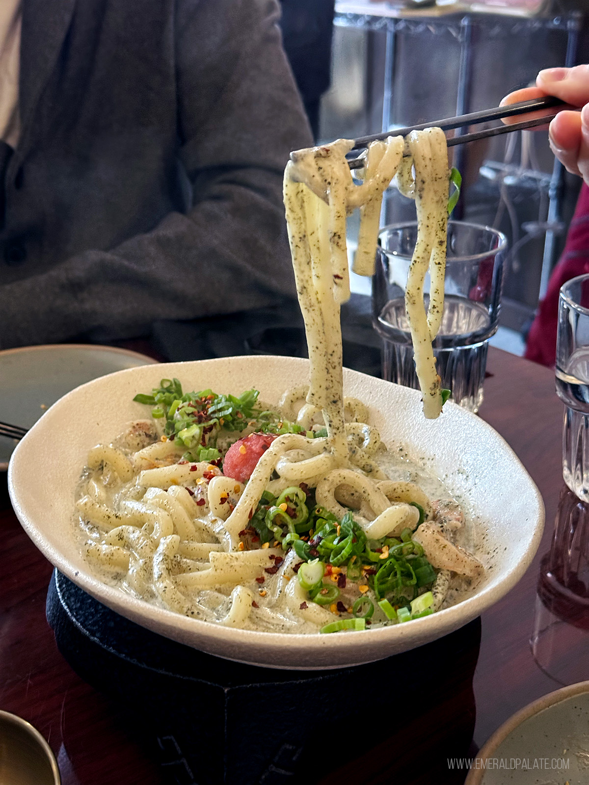 person pulling noodles with a chopstick at one of the best restaurants in Fremont Seattle