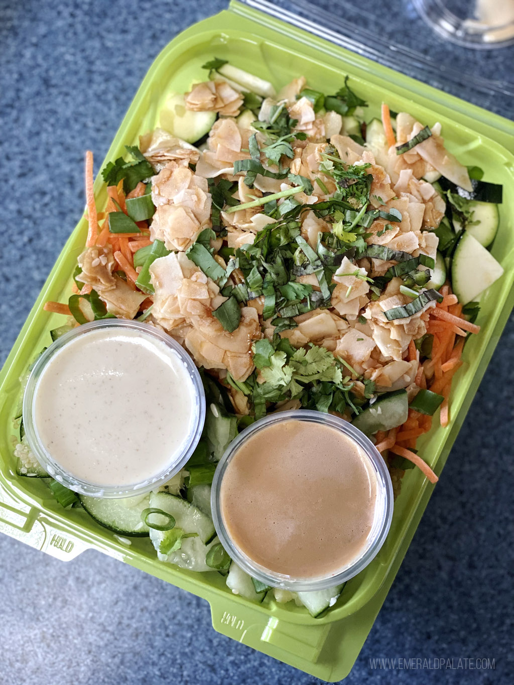 kale salad with coconut chips in a takeout container