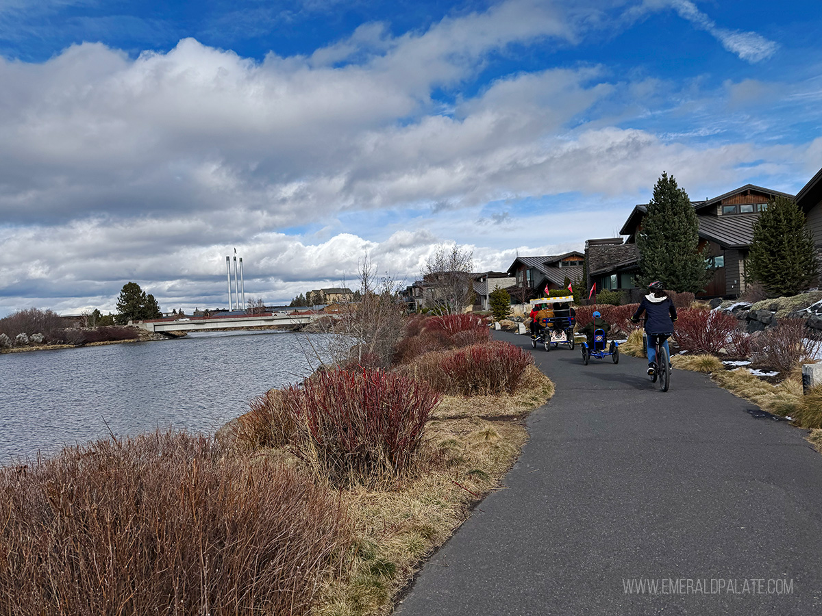 family biking along the Willamette River in Bend Oregon, one of the best things to do in Bend Oregon in winter