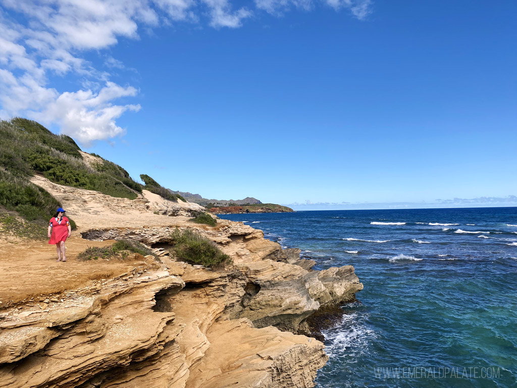 woman walking along the sea cliffs in Kauai