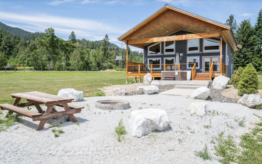 backyard of a cabin with a fire pit and picnic table