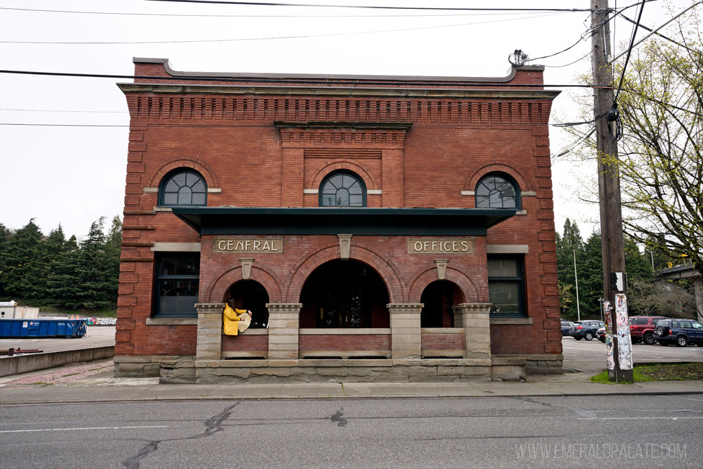 woman sitting on ledge of old brick building in Georgetown Seattle