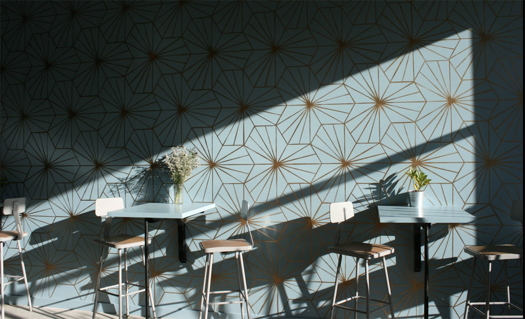 geometric wallpaper at a cafe with shadows from the sun