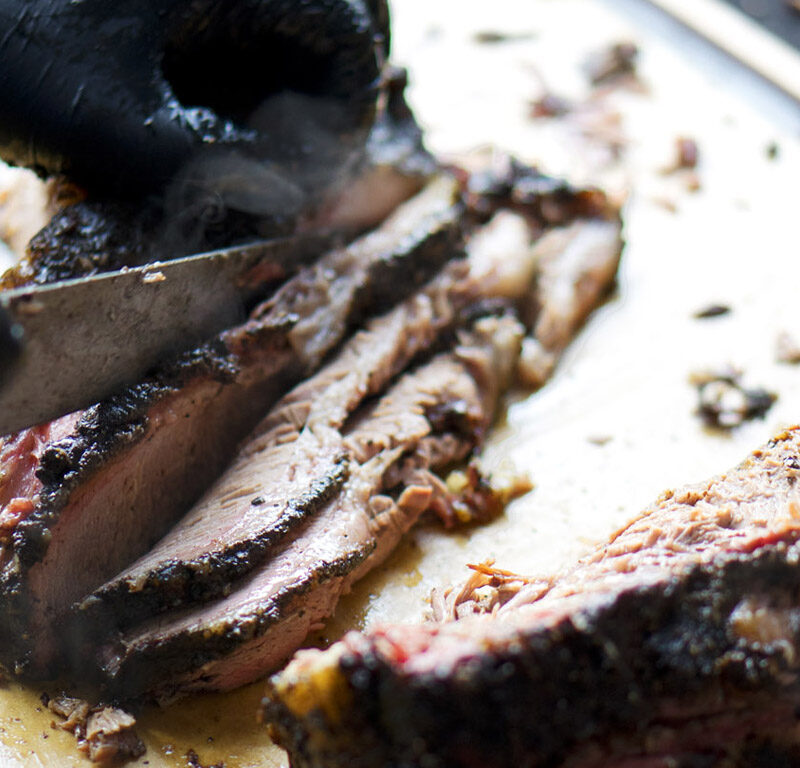 butcher cutting meat at one of the best butcher shops in Seattle