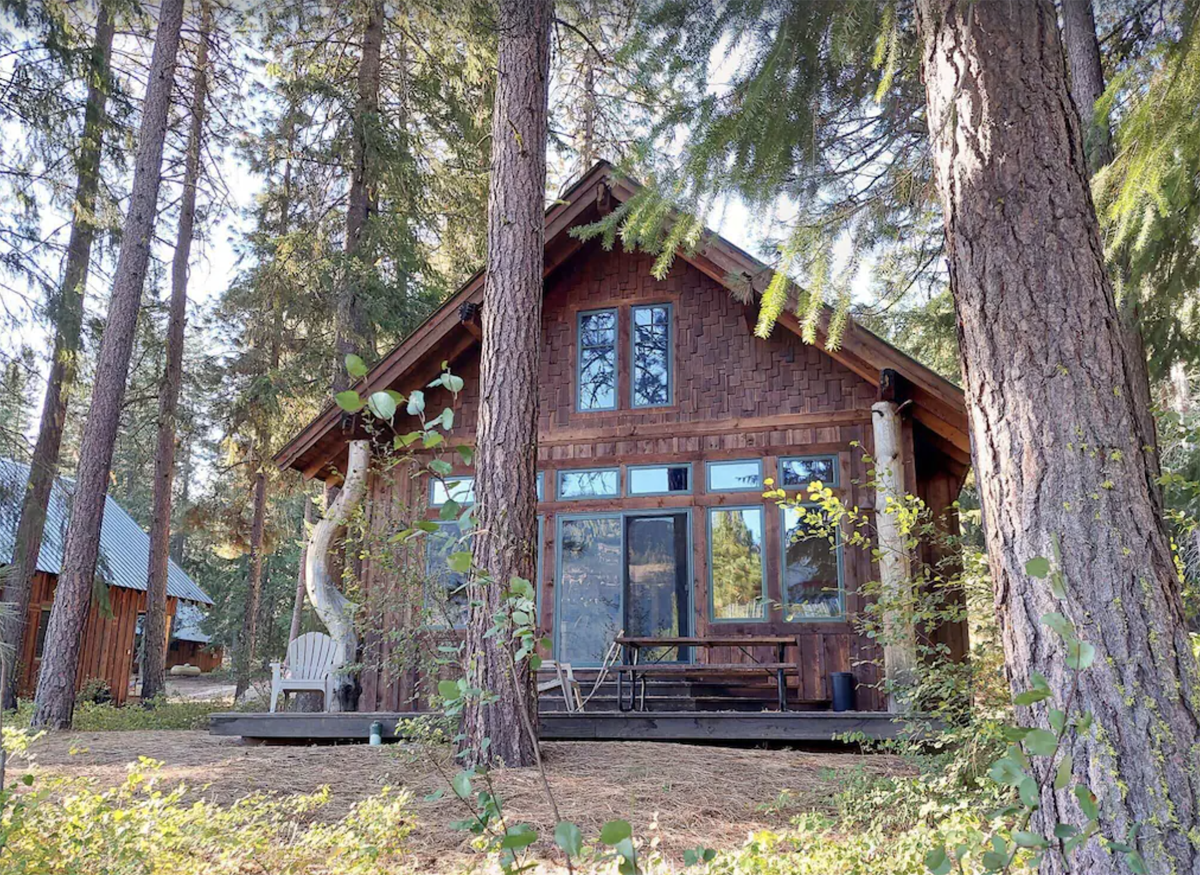 exterior of a cabin nestled in the woods