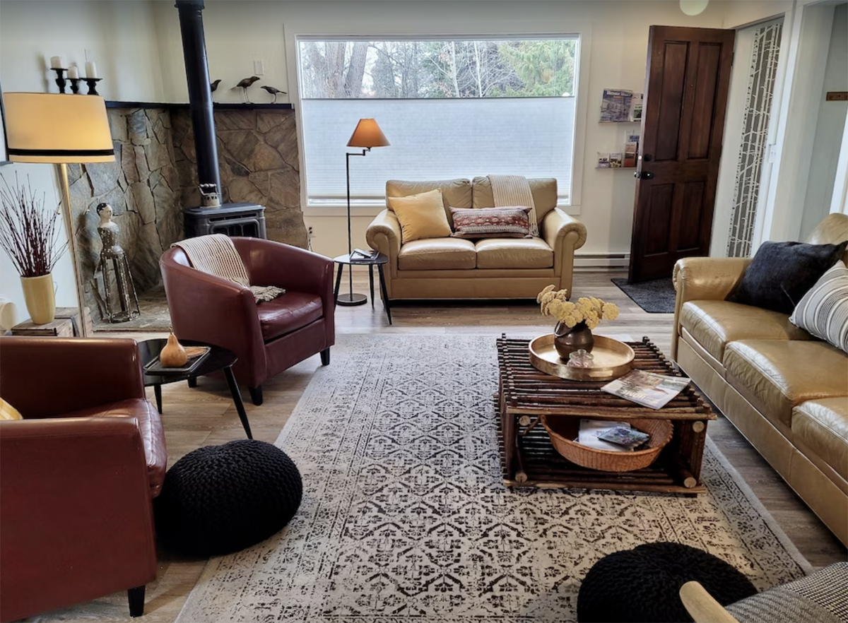 inside a living room of a cabin with a wood burning stove