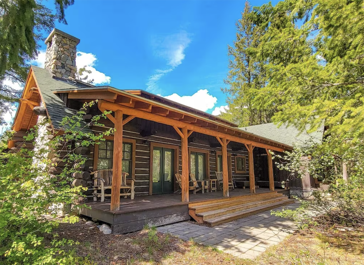 exterior of a log cabin with wrap around porch