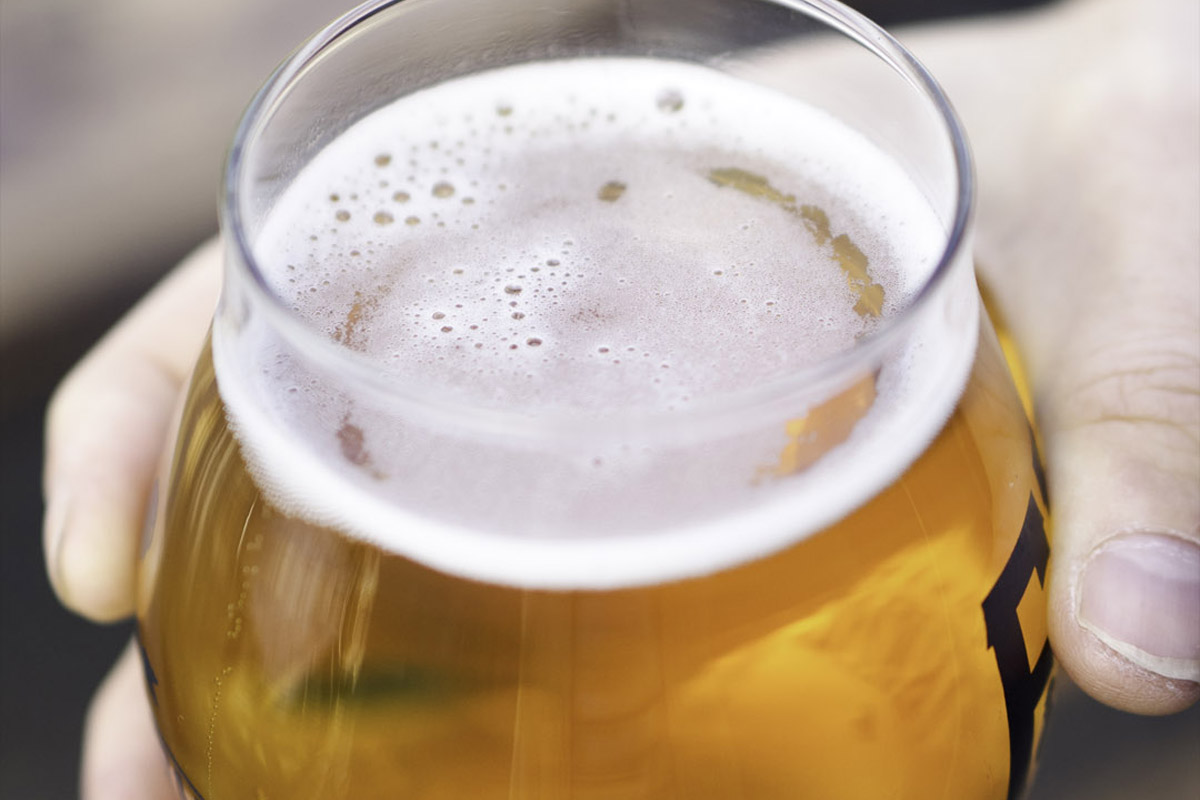 close up of person holding glass at one of the best craft beer bars in Seattle