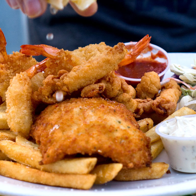 person squeezing lemon over the best fish and chips in Seattle