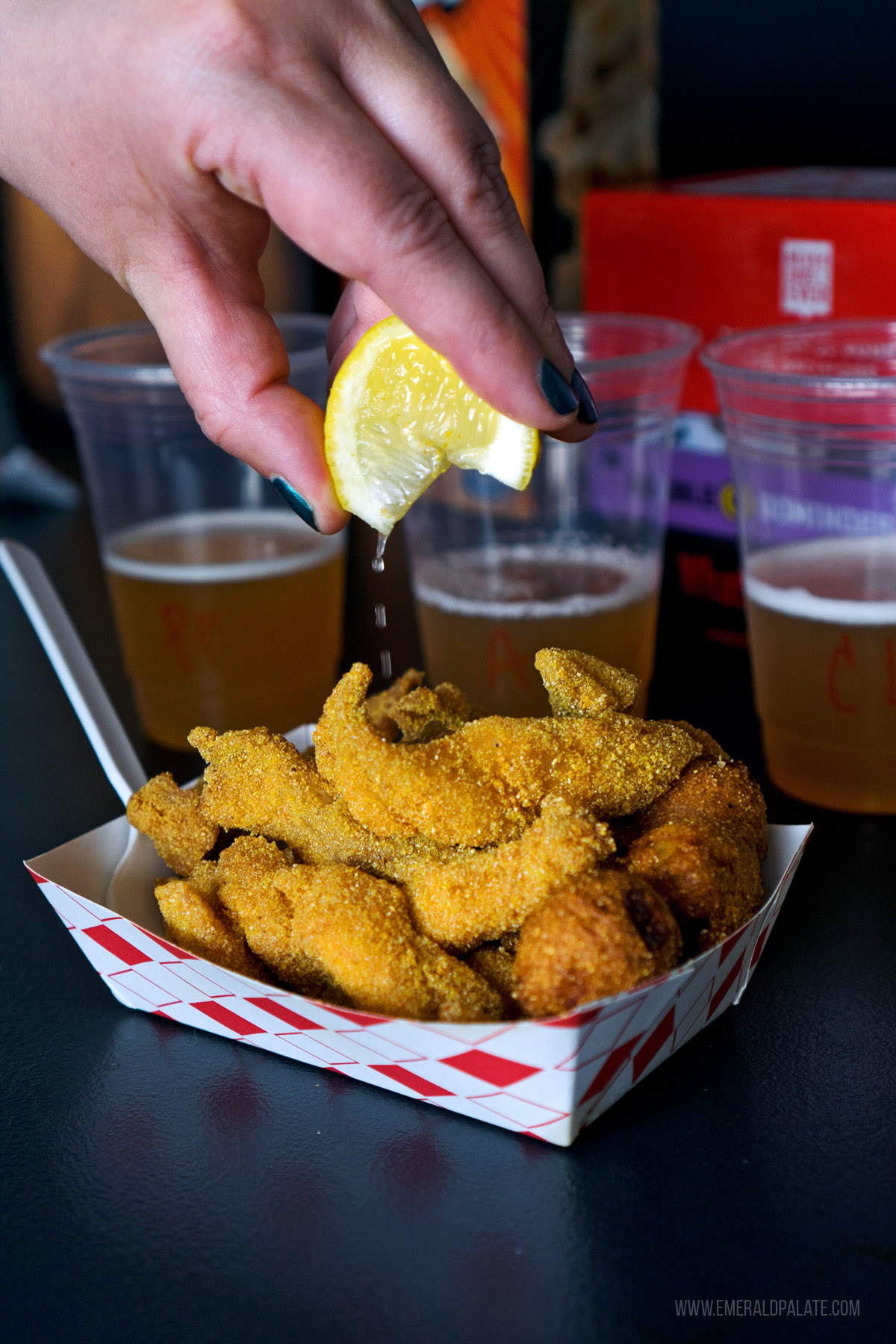 person squeezing lemon over fried catfish