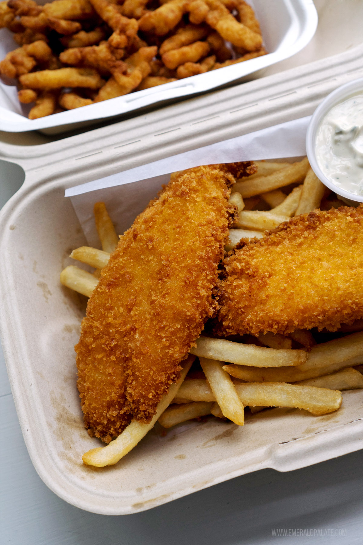 takeout containers of breaded fried cod and clam strips