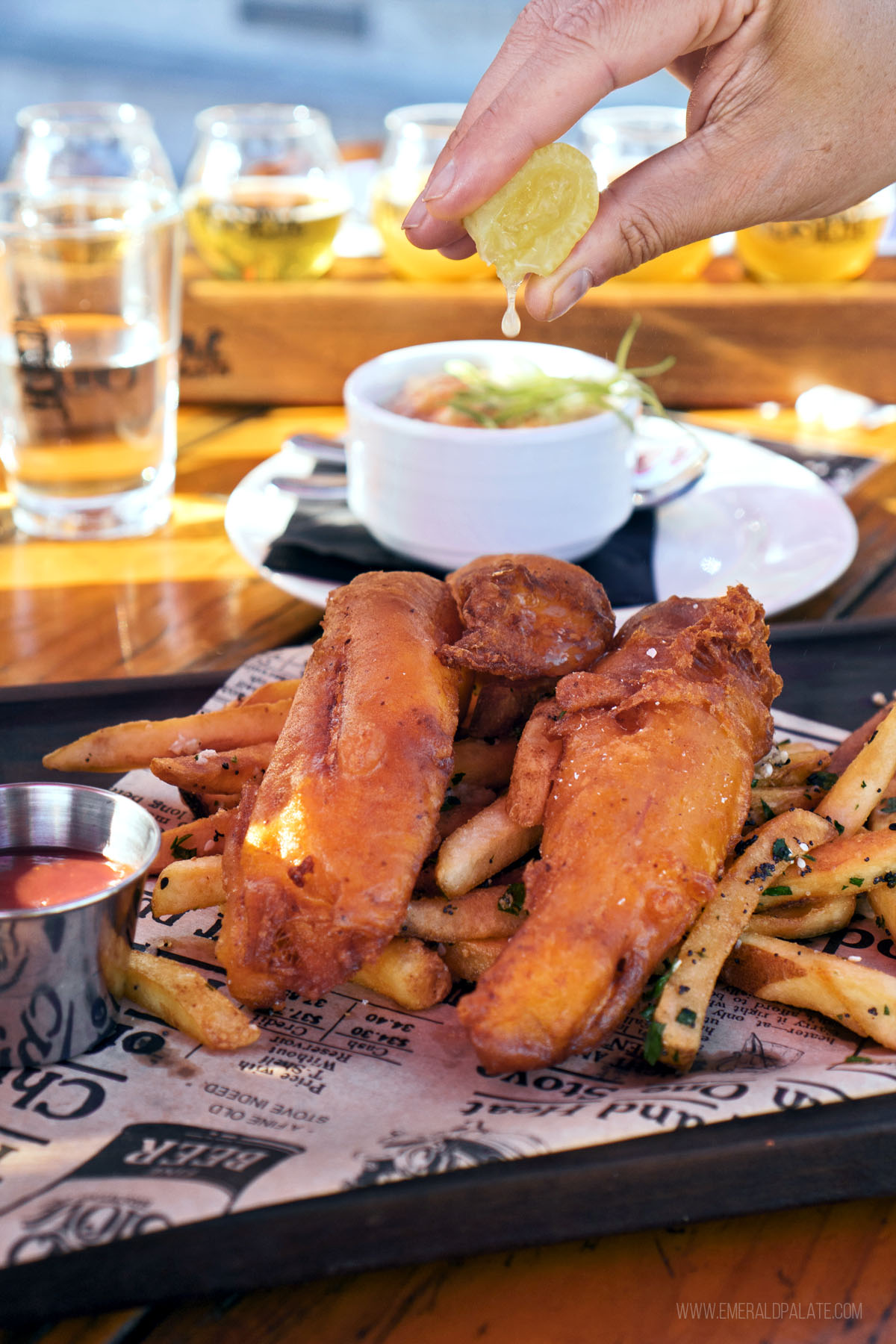 person squeezing lemon over a pile of the best fish and chips in Seattle