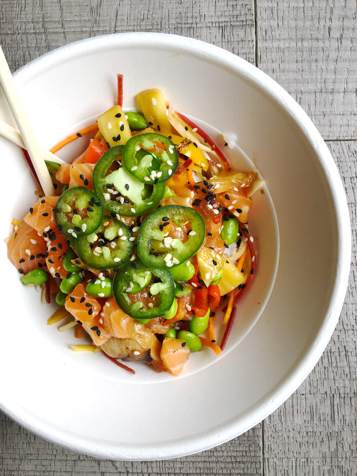 bowl of poke with jalapenos, mangos, and peppers