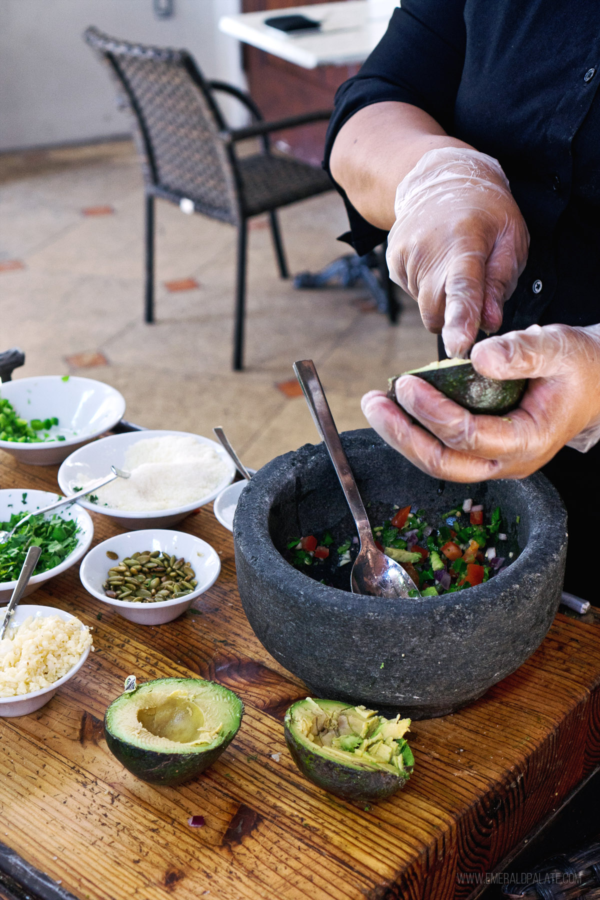 person making guacamole in a mortar and pestle
