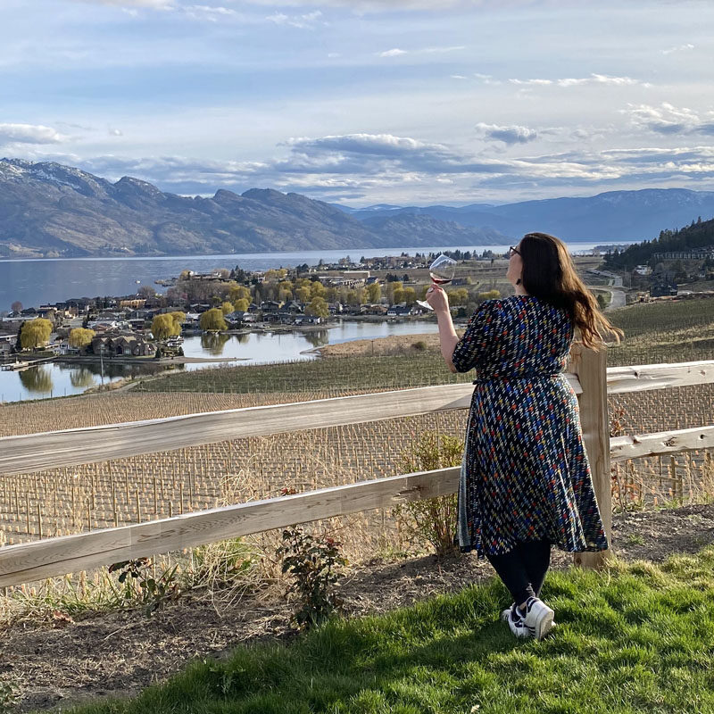 woman at a winery with views of Okanagan Lake during a weekend in Kelowna, Canada
