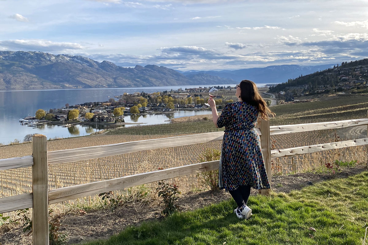 woman at a winery with views of Okanagan Lake during a weekend in Kelowna, Canada