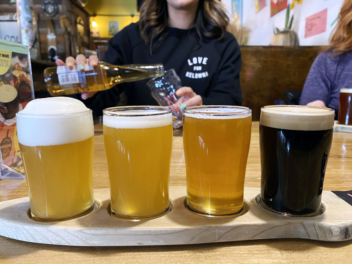 four beer tasters with woman pouring beer in background