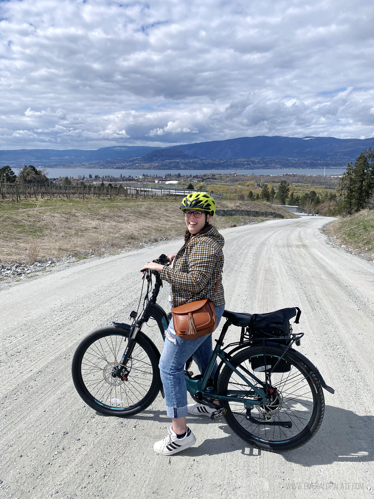 woman smiling on bike with Okanagan Lake in the background