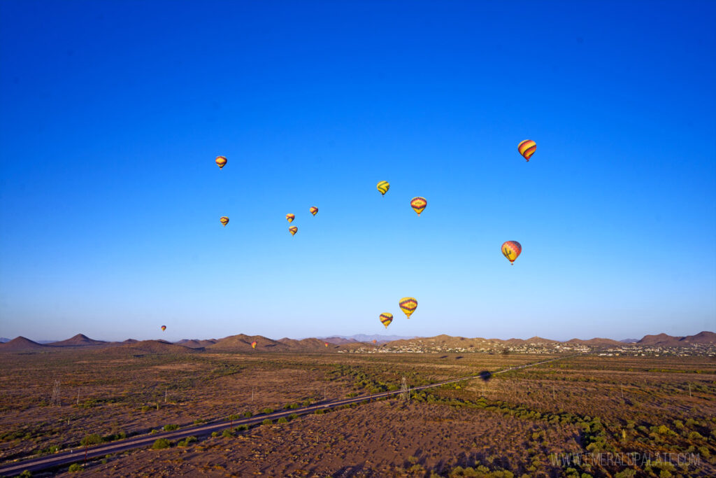 a bunch of hot air balloons floating in the blue sky