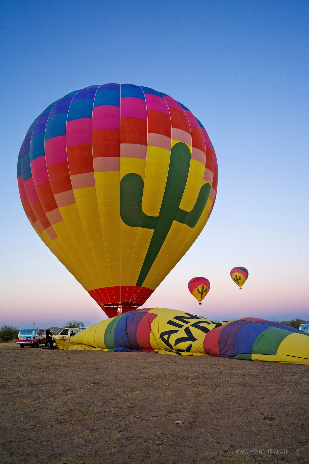 hot air balloons being blown up at sunrise