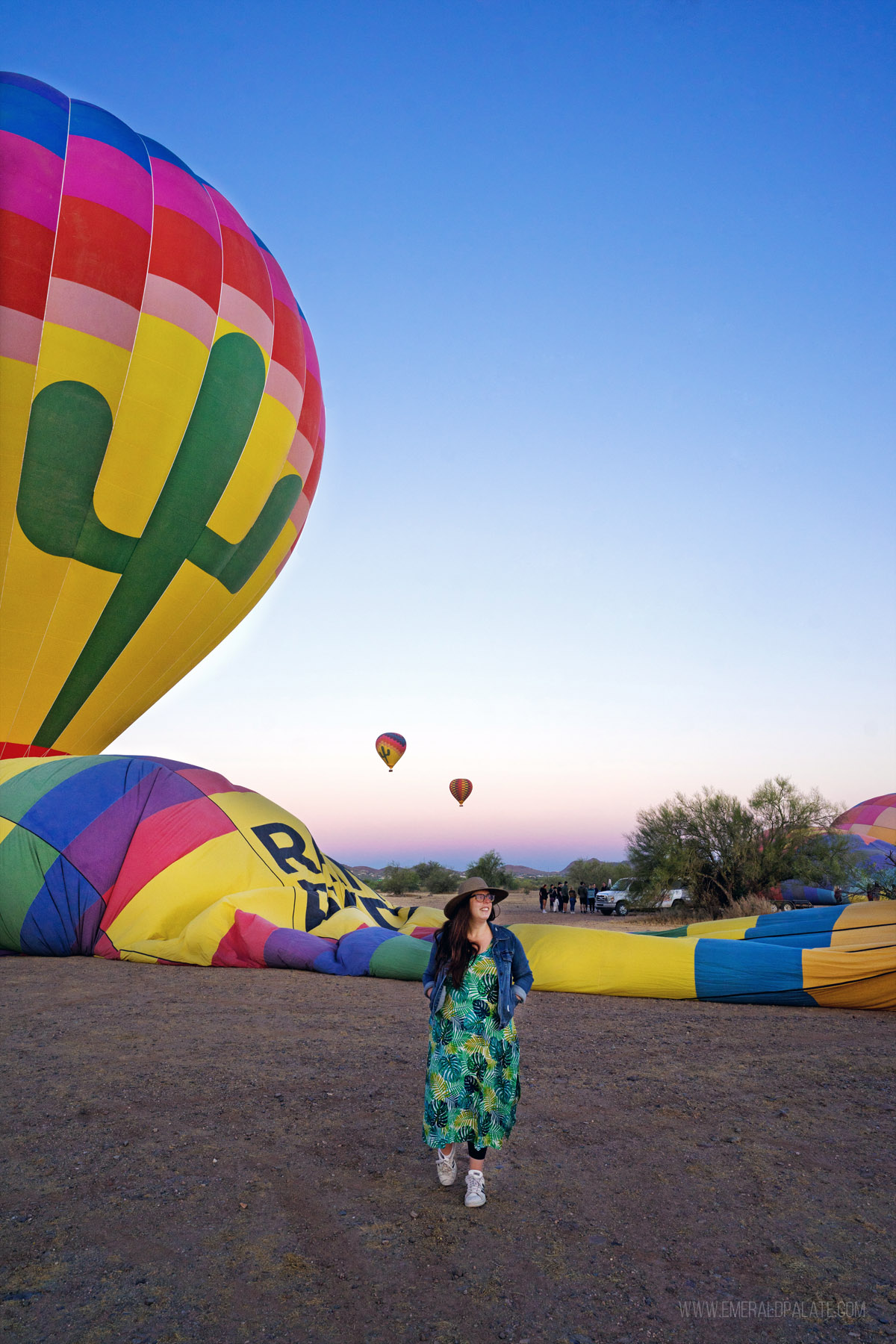 a woman laughing with hot air balloons in the background during a weekend trip to Scottsdale