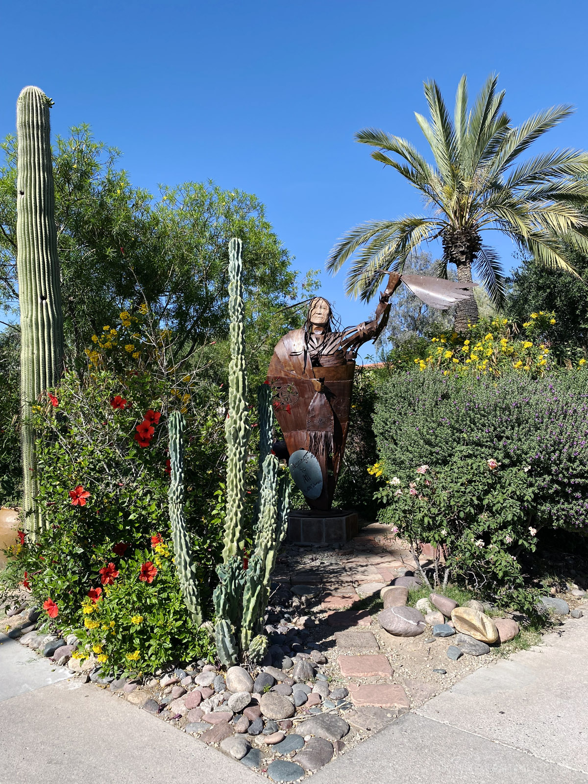 sculpture of an Indigenous person surrounded by cactus