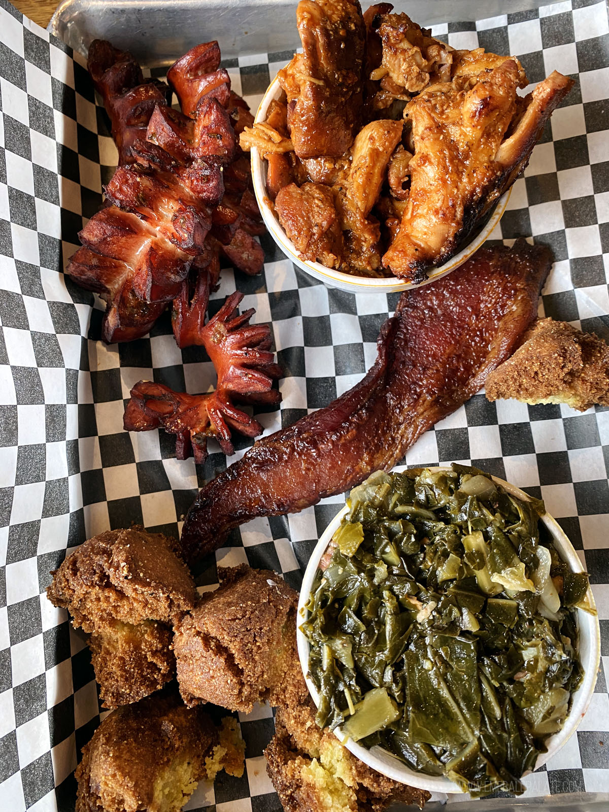 plate of smoked sausage, smoked chicken, collard greens, and pulled pork