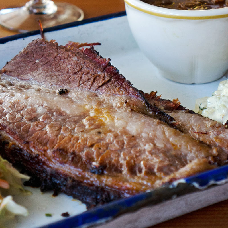 smoked brisket meat on a platter with sides at one of the best BBQ in Seattle restaurants