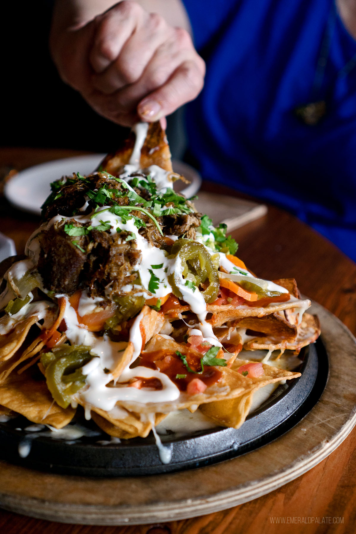 person grabbing from a pile of nachos