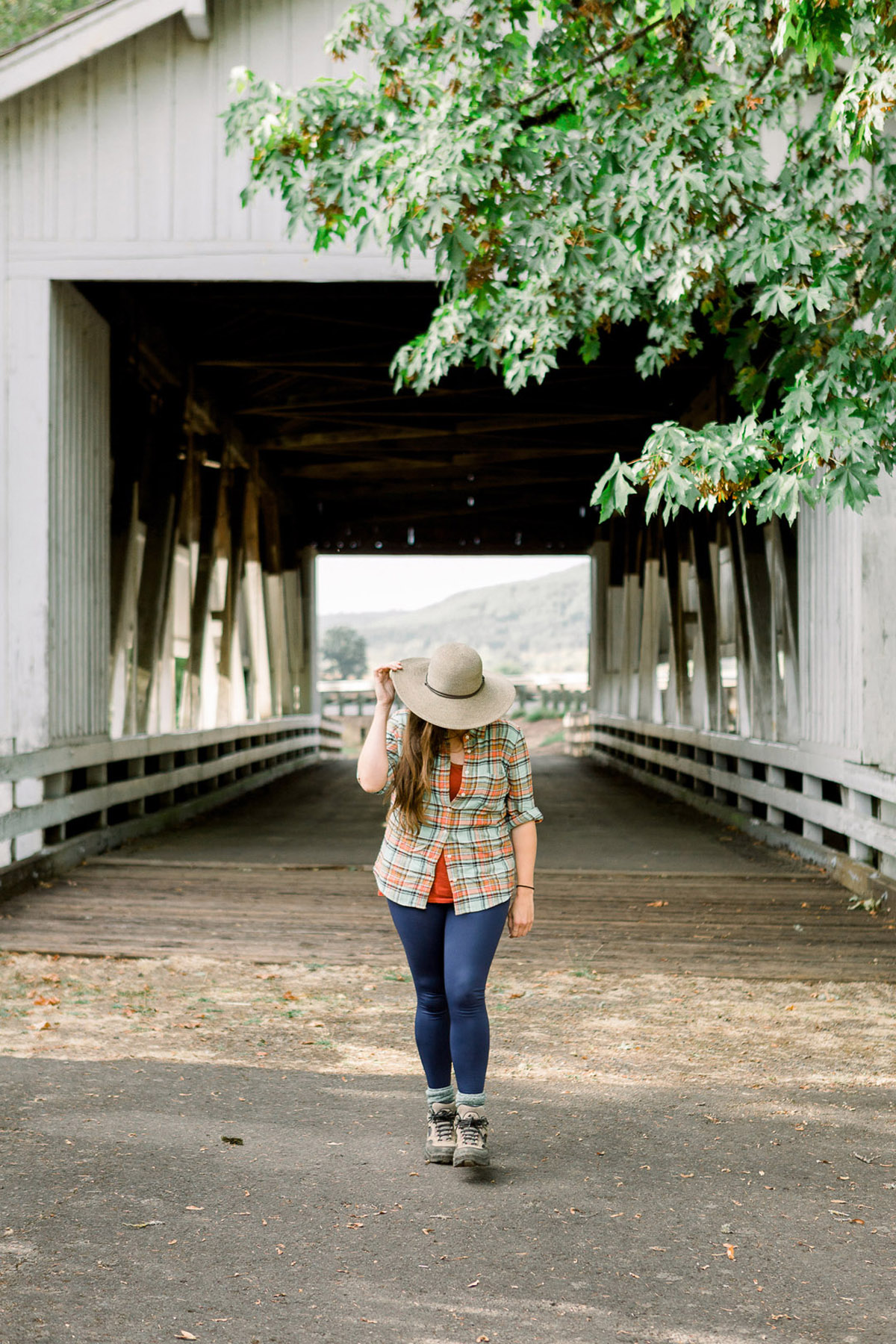 woman walking on a covered bridge near Eugene, OR