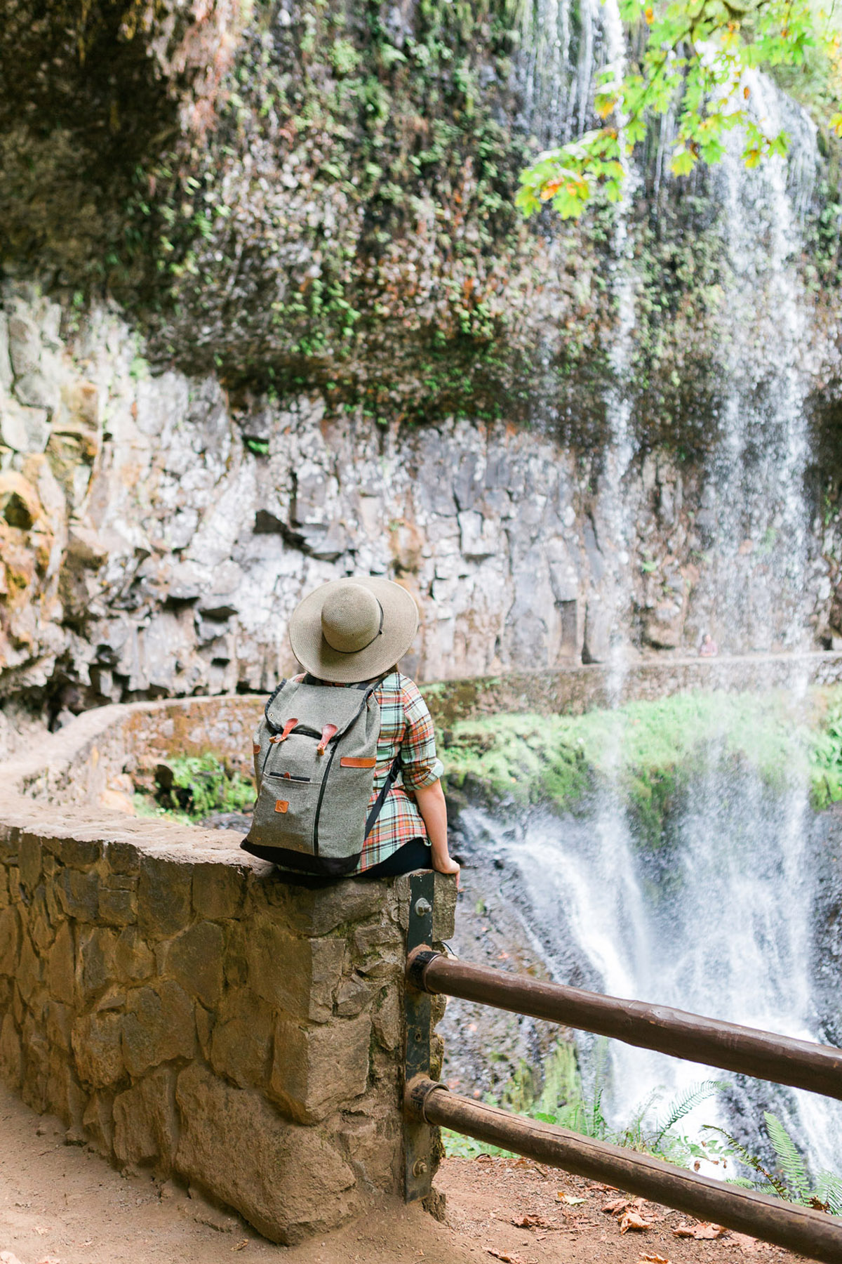 woman sitting on a ledge looking at a waterfall near Eugene