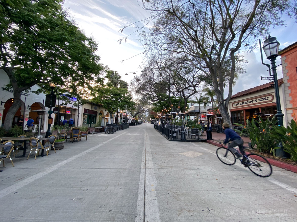 person biking down State Street, a must see during your weekend in Santa Barbara