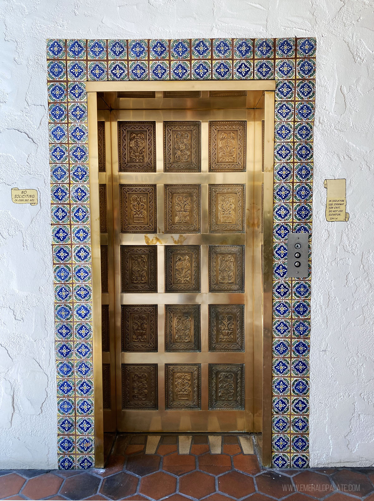 brass elevator door with Spanish tile trim