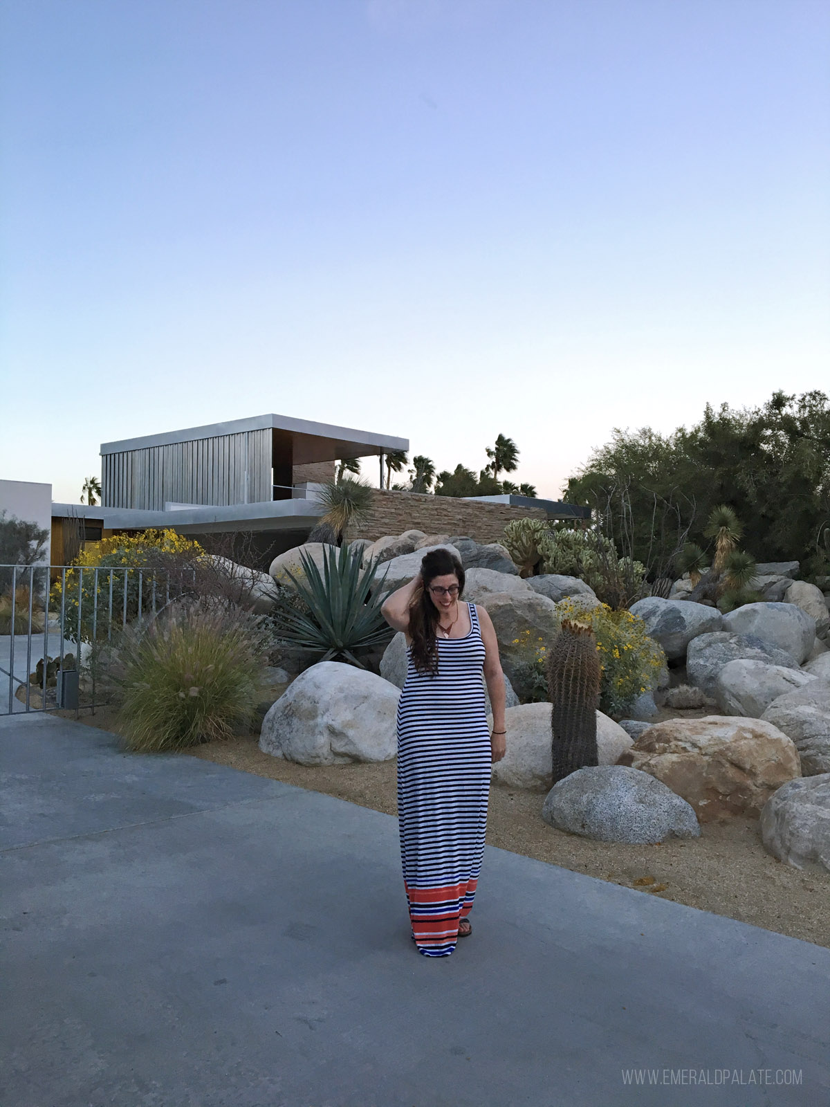woman standing in front of a famous mid century modern home in Palm Springs, a must do on your day trip to Joshua Tree
