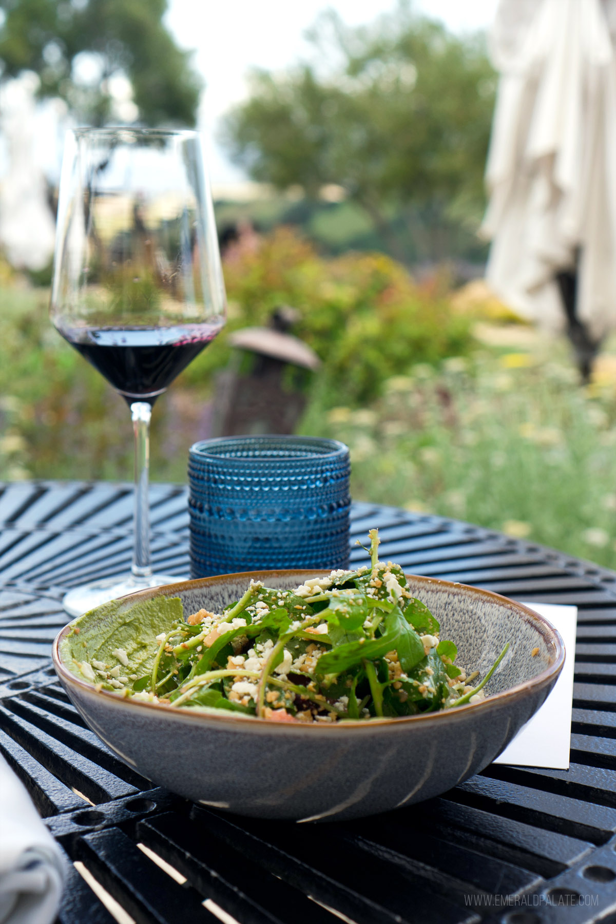 salad and wine on an outdoor bistro table