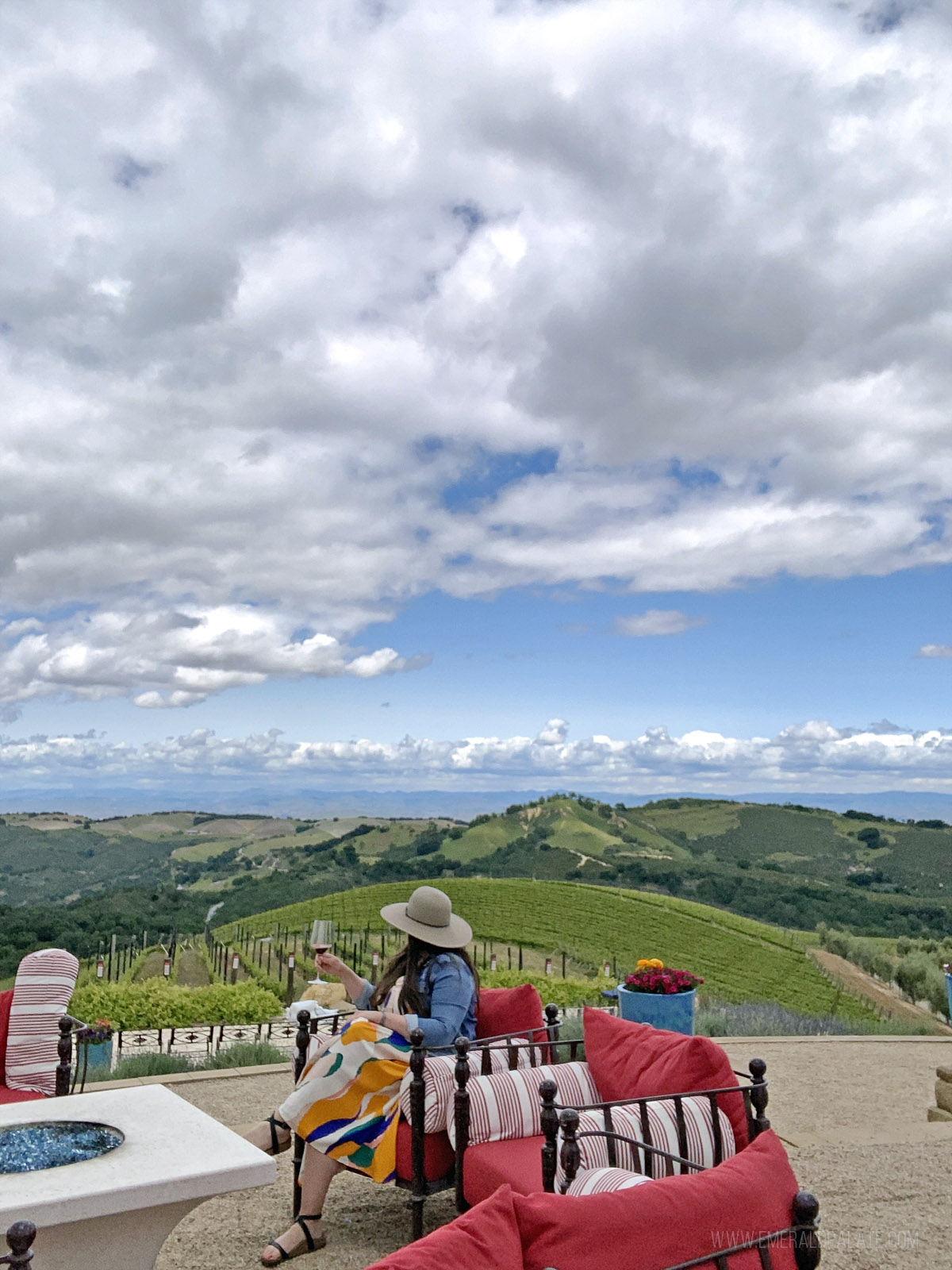 woman sitting on a winery patio overlooking wine country