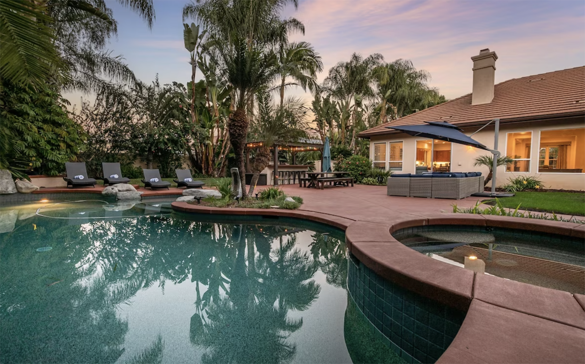 pool area with lounge chairs and palm trees