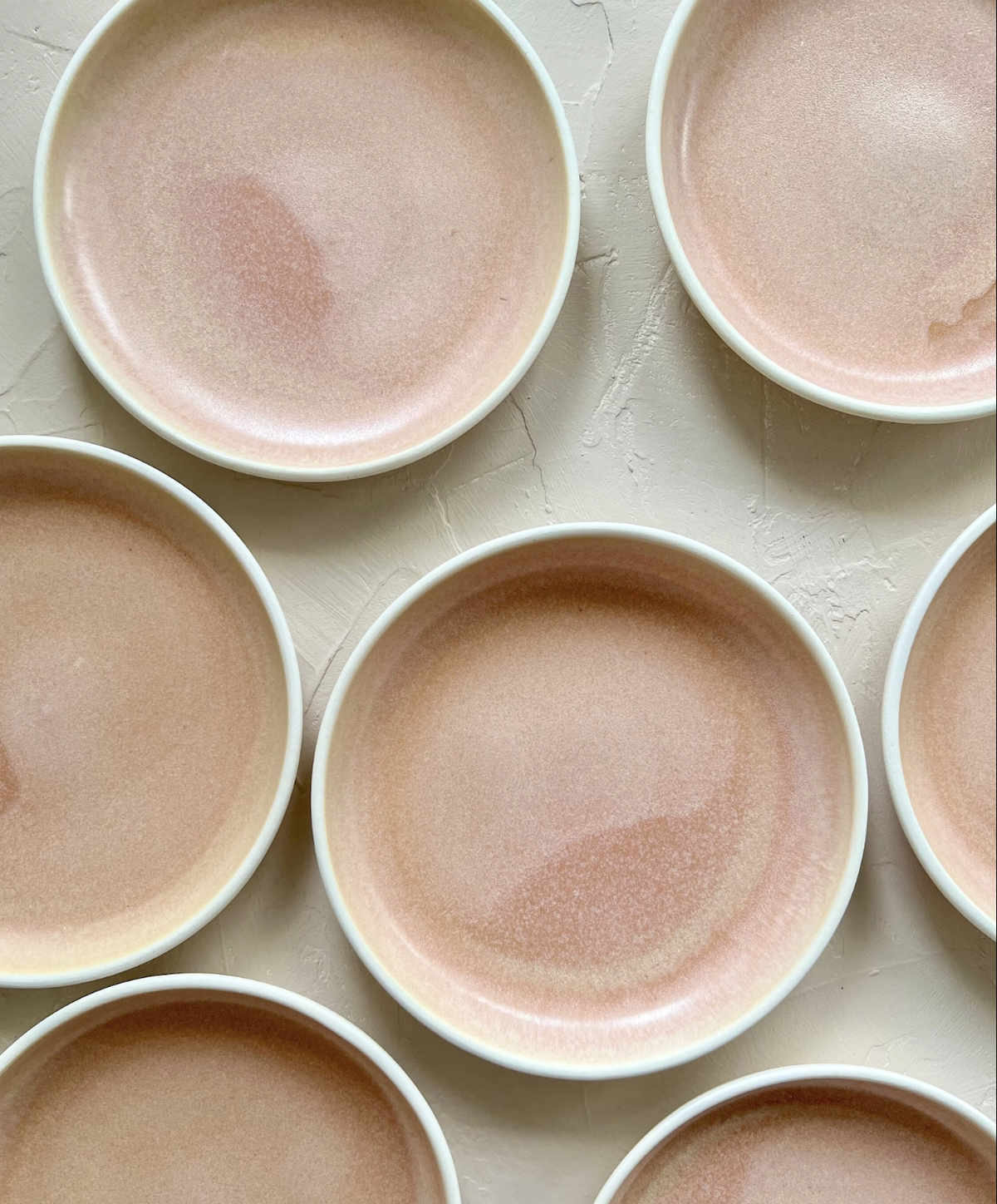 a bunch of neutral colored pottery plates from a Seattle ceramicist