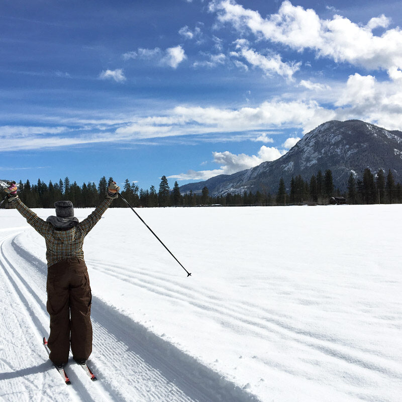 Woman celebrating while cross country skiing in Leavenworth, one of the best day trips from Seattle in winter