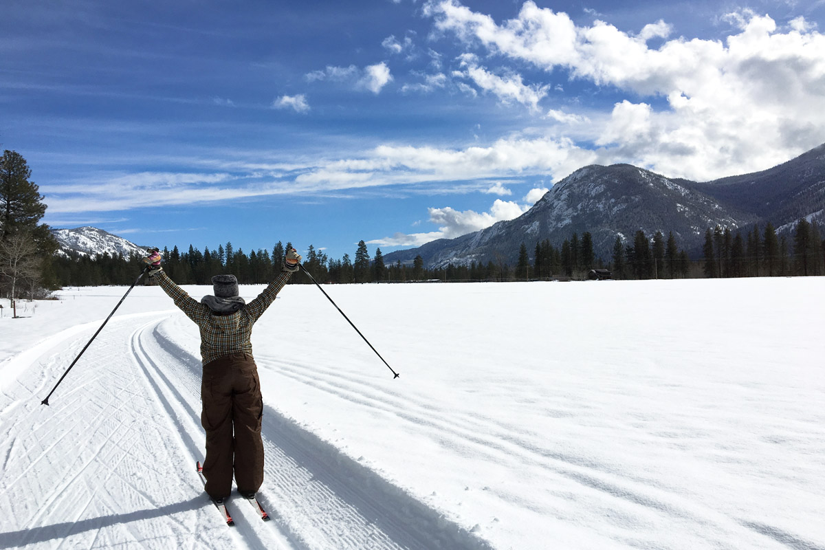 Woman celebrating while cross country skiing in Leavenworth, one of the best day trips from Seattle in winter