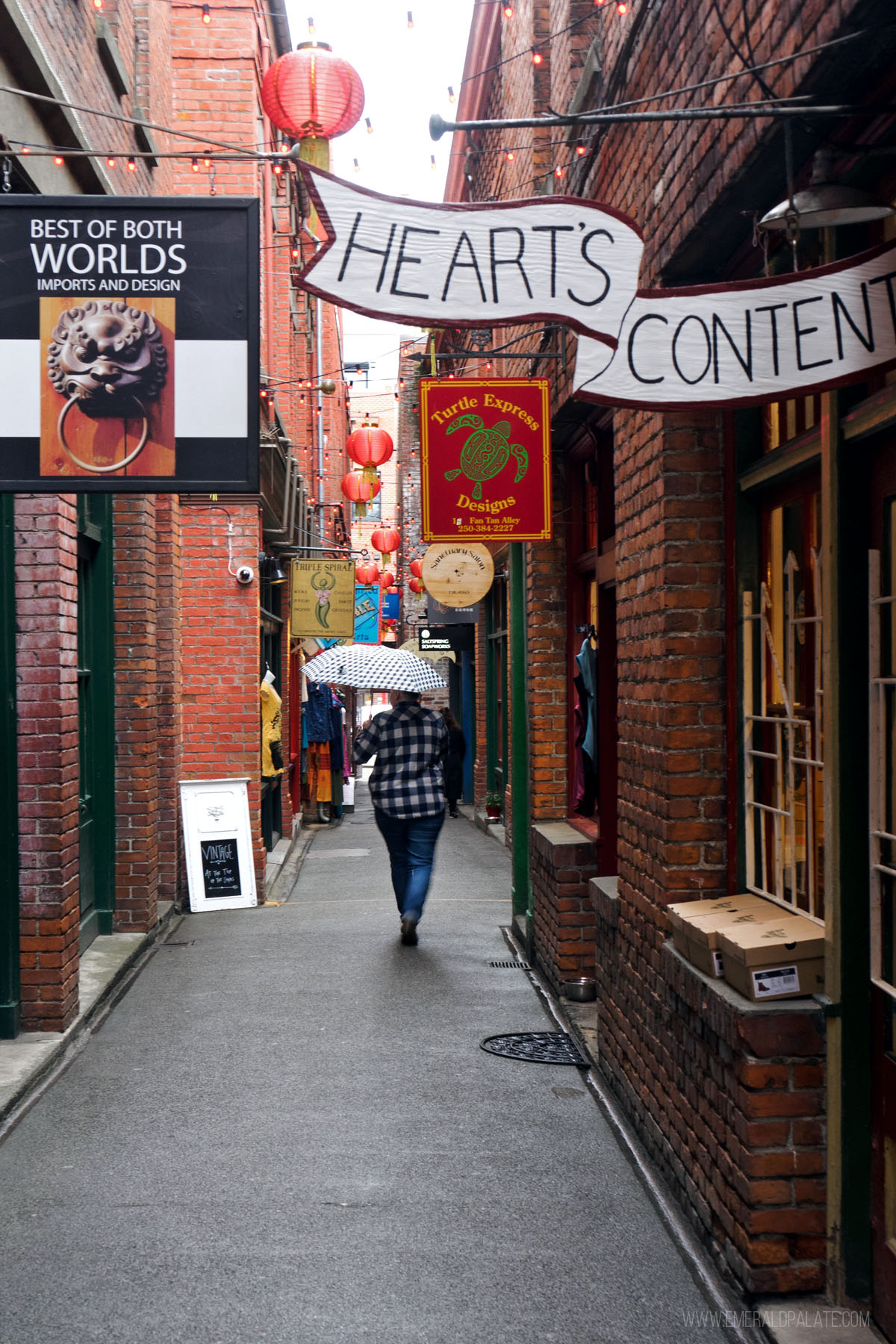 woman holding an umbrella walking through Fan Tan Alley, one of the most unique things to do in Victoria BC