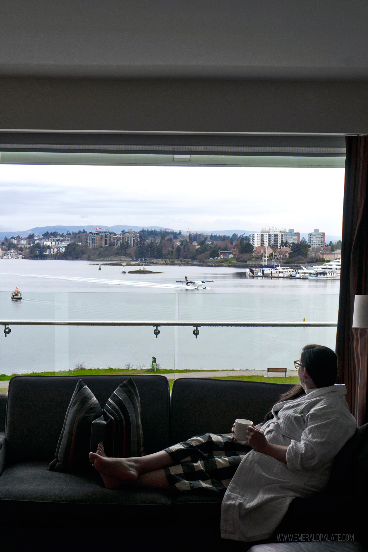 woman enjoying the view from the couch inside a waterfront hotel in Victoria BC