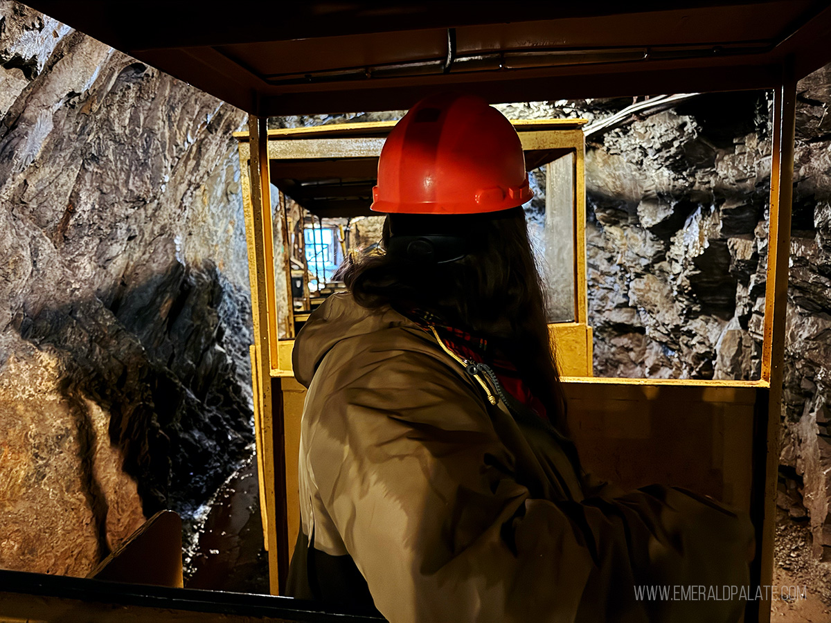 woman with a hard hat riding in a mine