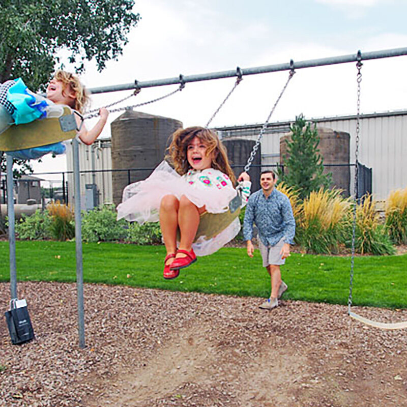 Kids being pushed on a swing, one of the best things to do in Seattle with kids