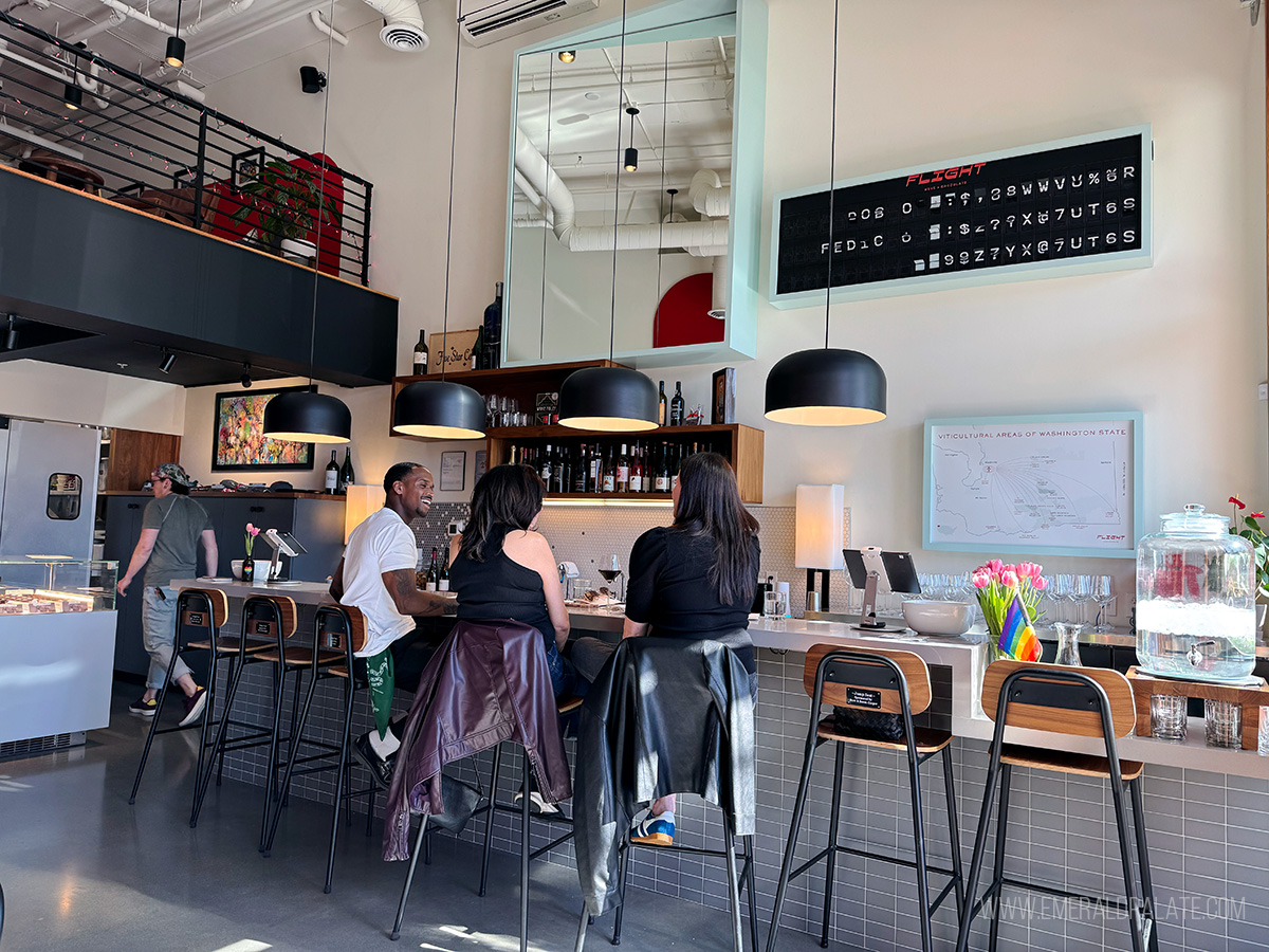 People laughing at the counter of one of the best wine bars in Seattle
