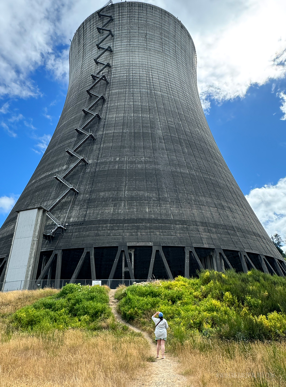 woman looking up at a large nuclear power tower in Washington state